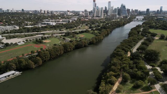 Aerial Establishing Shot of Austin Texas, drone flies down river towards downtown while panning up