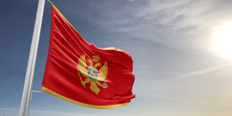 Montenegro national flag cloth fabric waving on beautiful sky grey Background. - obrazy, fototapety, plakaty