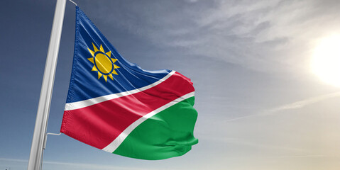 Namibia national flag cloth fabric waving on beautiful sky grey Background.