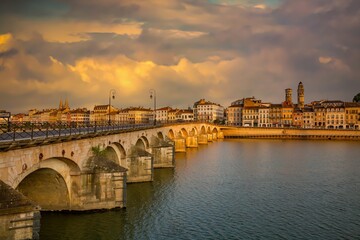 Fototapeta na wymiar Macon, France - 6/9/2015: The historic Saint-Laurent Bridge over the Soane river. It was among the few bridges of the region that were not destroyed during the Second World War.