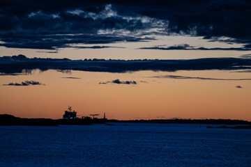 Silhouette of tanker ships in sunset light.