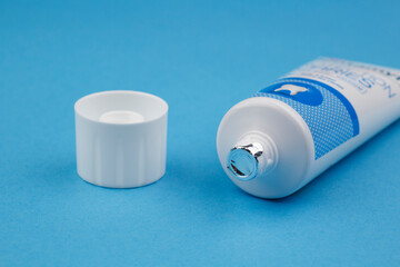 tube de dentifrice neuf sur fond bleu uni