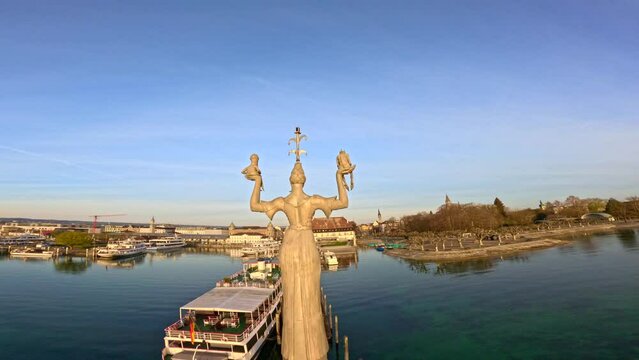 Rundumsicht auf die Imperia Statue und Flug &uuml;ber den ruhigen See bei Sonnenaufgang. Bodensee, Baden-W&uuml;rttemberg, Deutschland, Europa.
