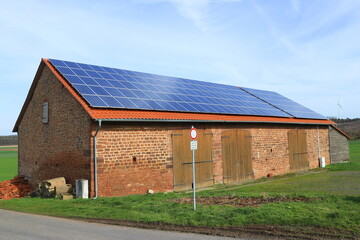 Fototapeta na wymiar Landwirtschaftliches Gebäude mit Solarzellen.