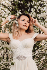 A beautiful bride near a cherry blossom. Spring Wedding