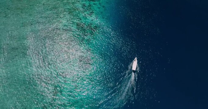 Aerial drone footage of speedboat on turquoise lagoon and coral reef of Gili Meno tropical island, Indonesia 