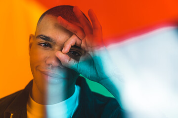 Close portrait of African American man with finger circle over his eye . High quality photo