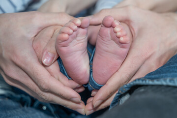 pieds de bébé dans les mains de ses parents - obrazy, fototapety, plakaty