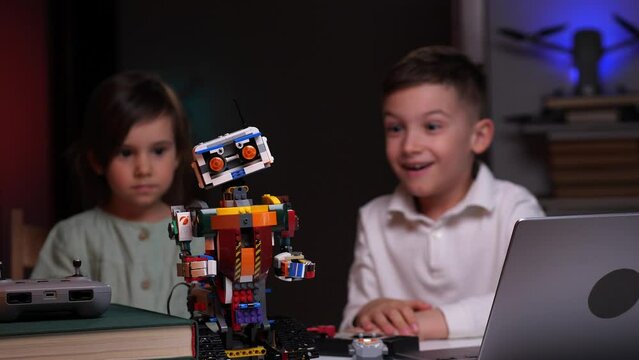 the boy with a little girl completes the construction of the robot