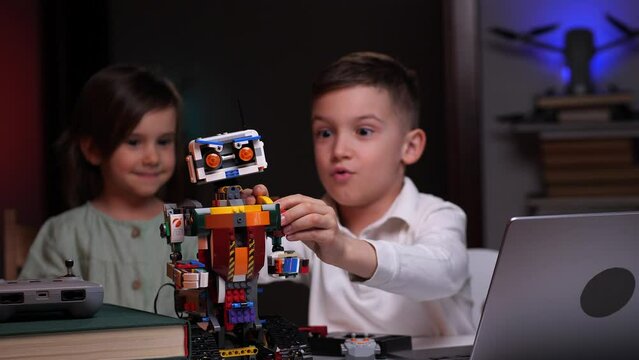 the boy with a little girl completes the construction of the robot