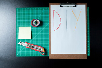 Handmade products cutting base with diy writing. Clipboard, papers, cardboard, scissors and colored adhesive. DIY concept. Craft concept.