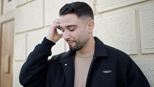Young arab man smiling confident listening audio message by the smartphone at street