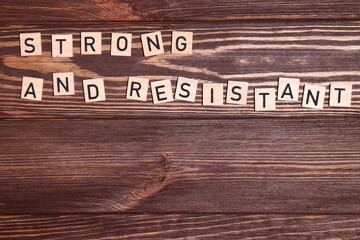 Strong and resistant phrase, lettering on wooden background