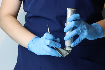 Health care professional wearing surgical gloves opening a laryngoscope to be use in an intubation