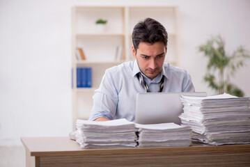 Young male employee and too much work in the office