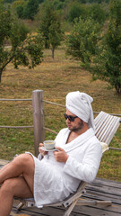 young man dressed in a white bathrobe and a bath towel 