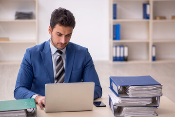 Young male employee and too much work in the office