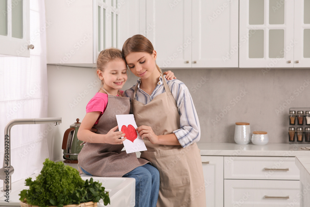 Sticker Little daughter congratulating mom with greeting card in kitchen. Happy Mother's Day