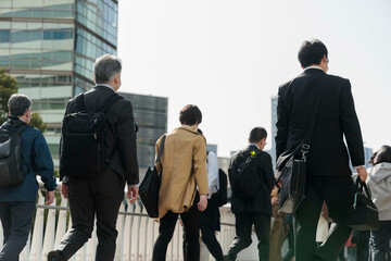 Obraz premium 朝の通勤をするビジネスマンたちの後ろ姿