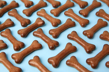 Bone shaped dog cookies on light blue background, closeup
