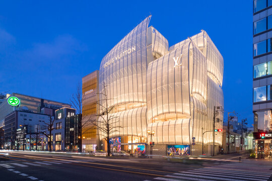 Louis Vuitton Maison Osaka Midosuji. The facade, designed by Jun Aoki to resemble a sailing ship, rises white in the dark night.