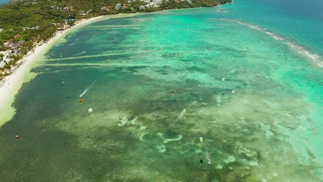 Tropical beach with turquoise water and kitesurfers, from above. Kitesurfing on a tropical island. Boracay, Philippines