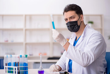 Young male chemist working at the lab