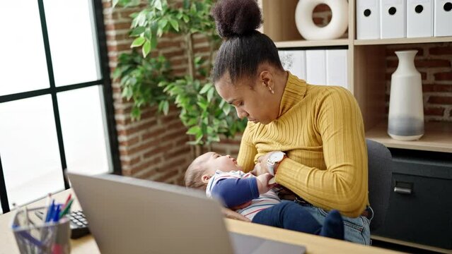 Mother and son business worker working while breastfeeding baby at home