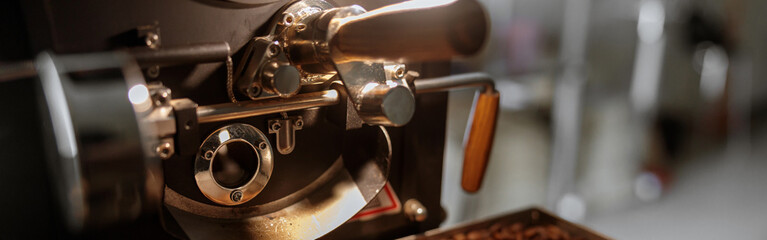 Fototapeta na wymiar Industrial coffee roasting machine with brown coffee beans