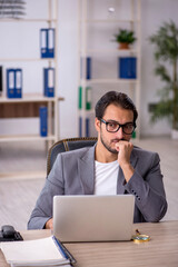 Fototapeta premium Young male employee working in the office
