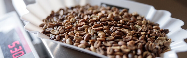 Bowls of roasted coffee beans on electronic scales