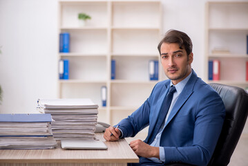 Young male employee and too much work in the office