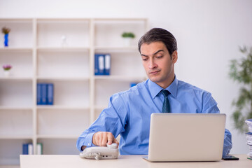 Young male employee and too much work in the office