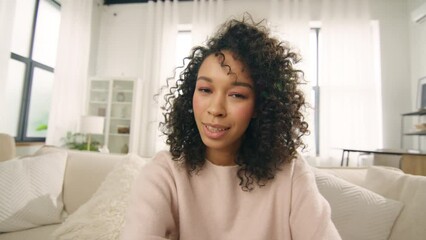 Young woman of color speaking on video call. Vlogger with afro hairstyle using smartphone talking at camera webcam online, selfie call, record lifestyle vlog, blogger communicating online streaming - Powered by Adobe