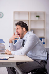 Naklejka premium Young male employee working in the office