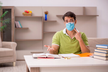 Young male student preparing for exams at home during pandemic