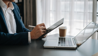 Businessman hand using smart phone laptop and tablet with social network diagram on desk as concept