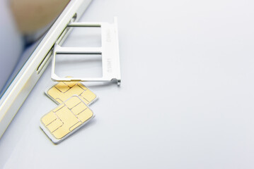 Broadband 5G mobile communication technology concept : SIM card tray / dual SIM card slot with two nano SIM cards on white background. SIM stores international mobile subscriber identity IMSI number. - obrazy, fototapety, plakaty