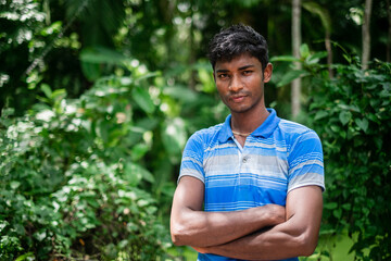 Portrait of a south asian young black village boy standing within nature 