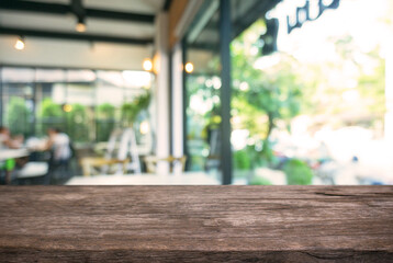 Empty wooden table in front of abstract blurred background of coffee shop . can be used for display Mock up  of product