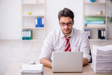 Fototapeta premium Young male employee and too much work in the office