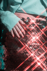 Fashion concept. Background of woman torso with red shining skirt and green jacket. On skirt star flare filter effect applied. Retro and disco style. Toned image with red and green color