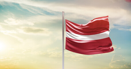 Latvia national flag waving in beautiful sky. The symbol of the state on wavy silk fabric.