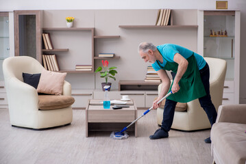 Old male contractor cleaning the house