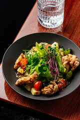 warm salad with chicken, vegetables and herbs. restaurant menu