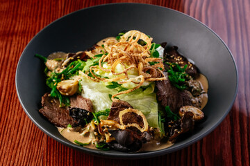 warm salad with beef, vegetables and herbs. restaurant menu