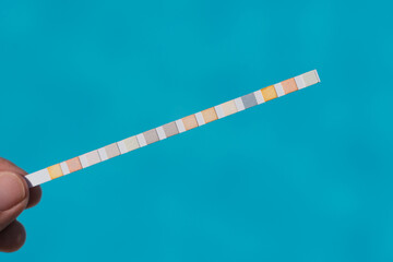 Test strip for measuring water indicators on a background blue water