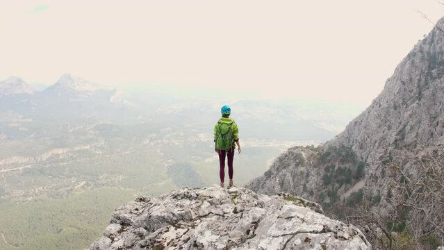 climber goes along the rocky ridge. girl climbs mountains in slow motion. the concept of adventure and hiking in the mountains. Türkiye. Antalya.