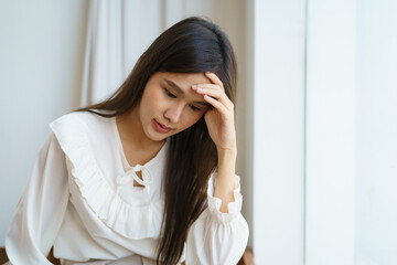 Unhappy - stressful Asian young woman having a depression disease, woman got a headache and touching on her head.