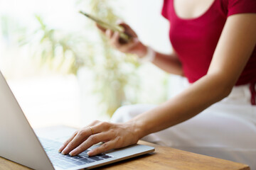 Naklejka premium Beautiful Asian young woman working in co-working space in coffee shop.